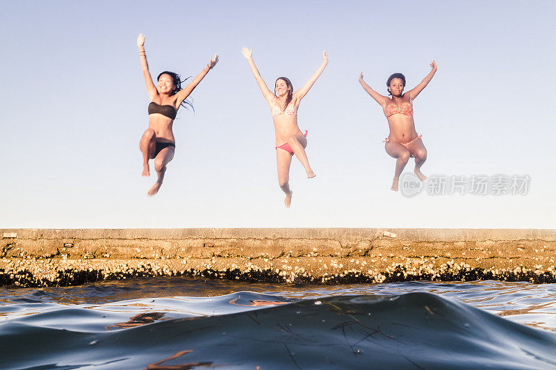 三个女人在夏天跳进海里