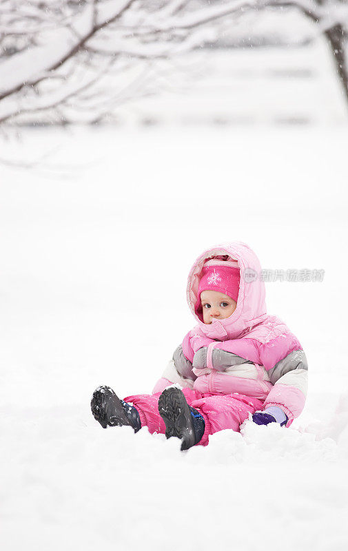 坐在雪地里的小女孩