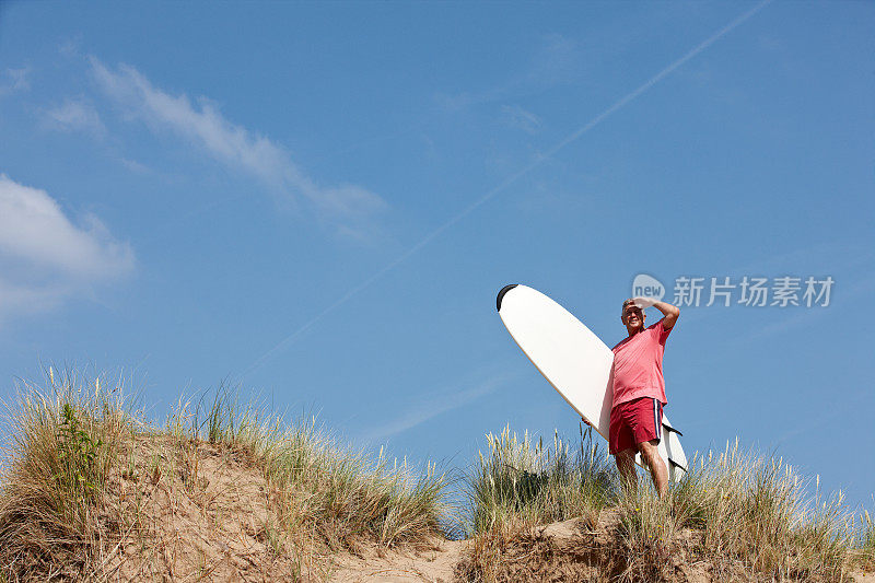 一个老男人在海滩上冲浪