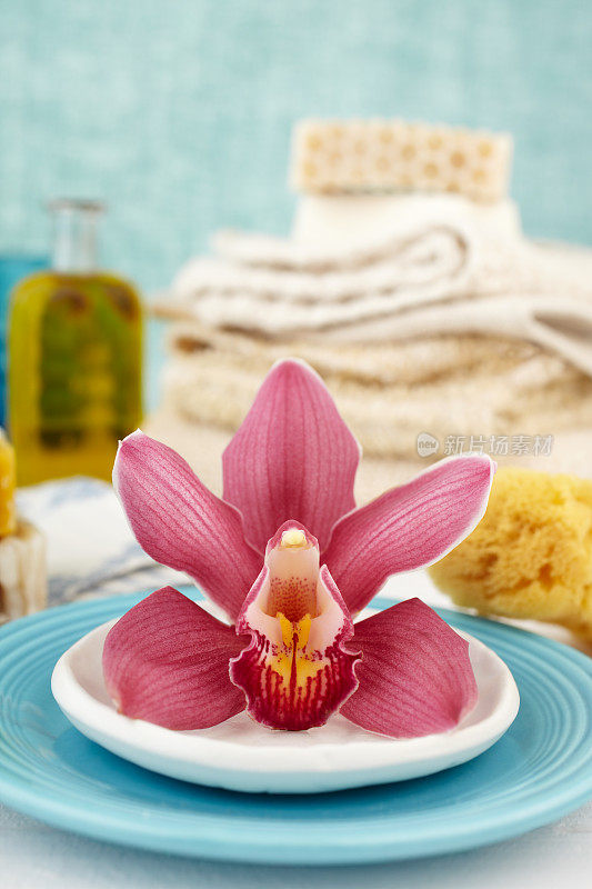 紫色兰花，肥皂，毛巾和海绵的水疗静物