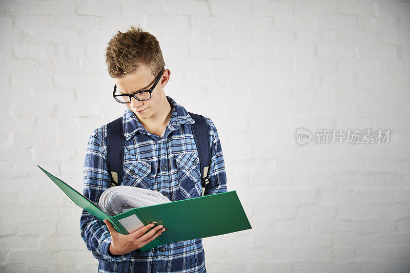 一个十几岁的男孩在看文件夹