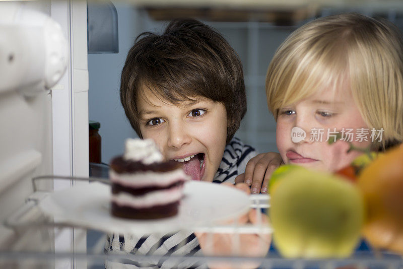两个男孩晚上在冰箱里找蛋糕