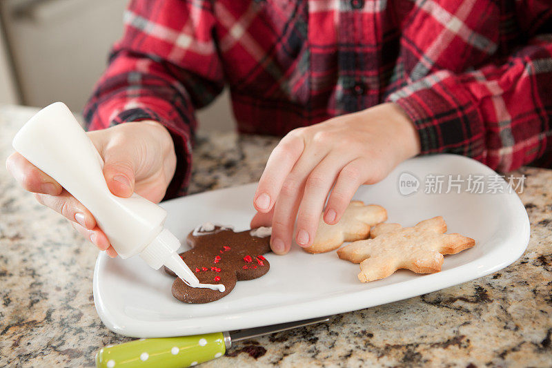 小男孩装饰圣诞饼干在厨房赫兹