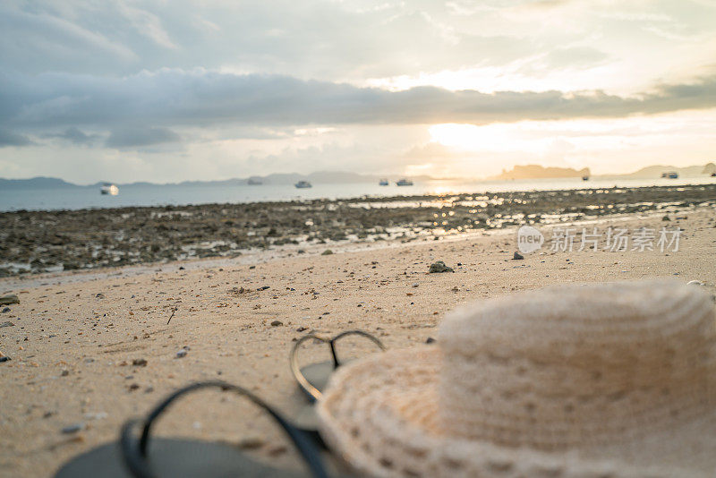 人字拖和太阳帽在沙滩上