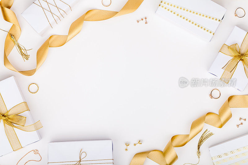 金色珠宝和礼品盒在白色背景与文本复制空间。时尚和购物的概念。婚礼、结婚或生日作文。平躺，俯视图
