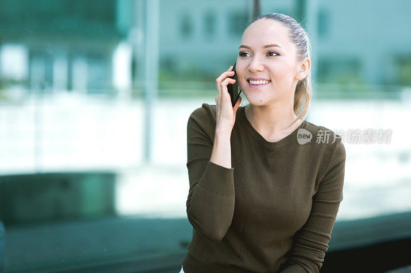 美丽的年轻女子在现实生活中使用智能手机