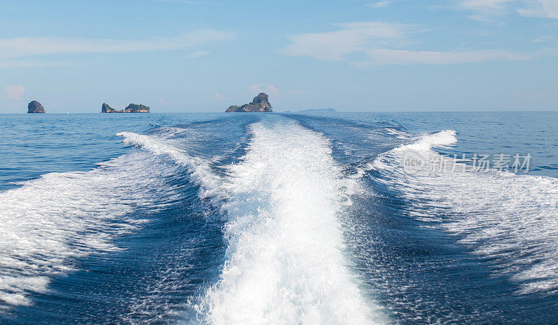 海浪从一个高速船和岛屿的背景