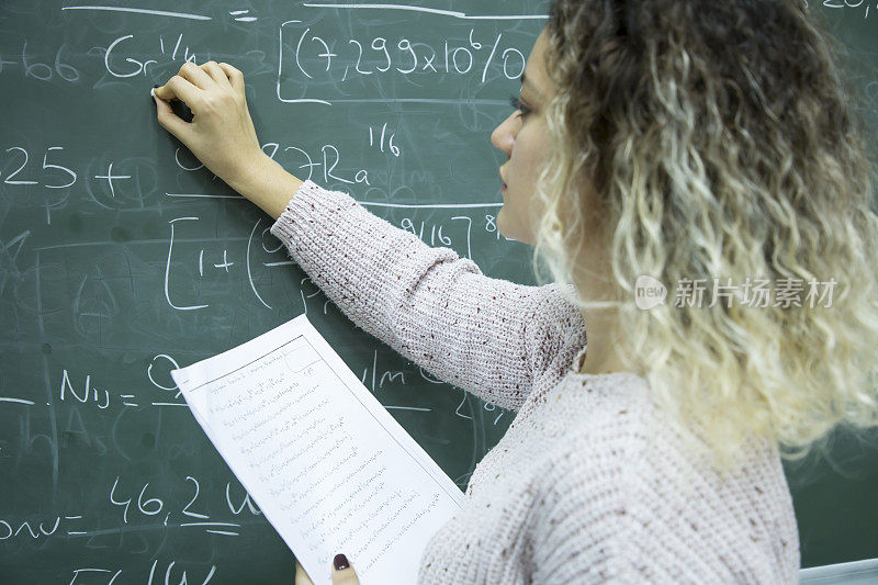 女同学在黑板前写数学公式