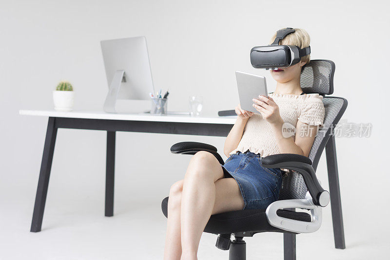 女商人戴着VR眼镜使用平板电脑