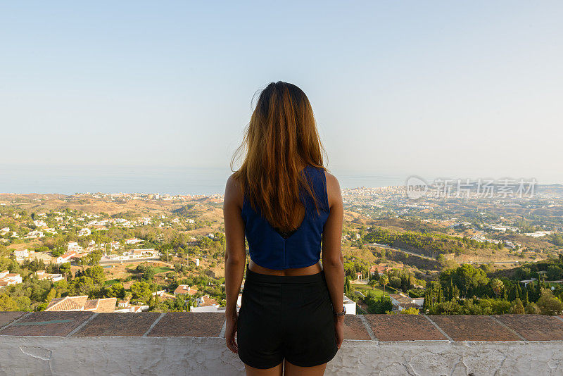 年轻的亚洲女游客欣赏风景的后视图