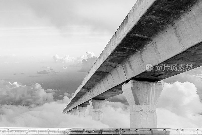 高速公路、高速公路、高速公路是现代城市的交通基础设施，城市景观映衬着多云的天空背景。