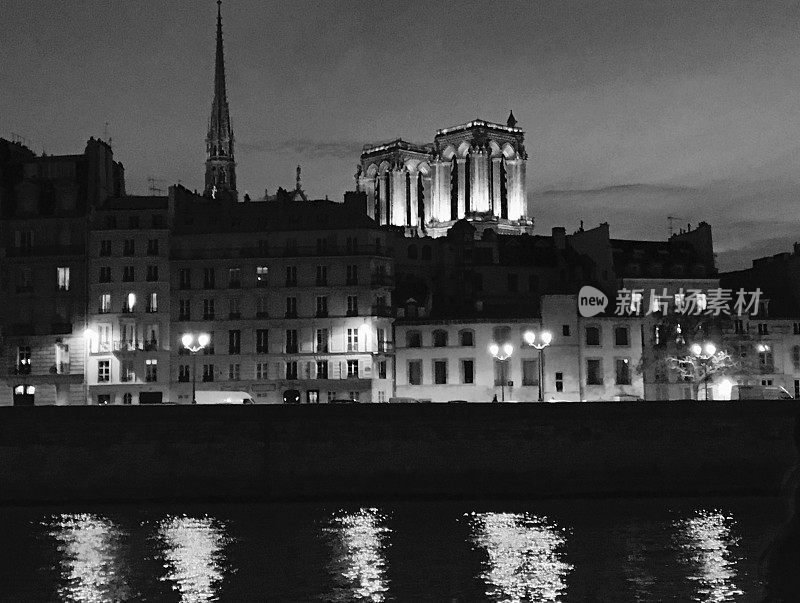 巴黎圣母院和塞纳河城楼夜间的黑白照片。