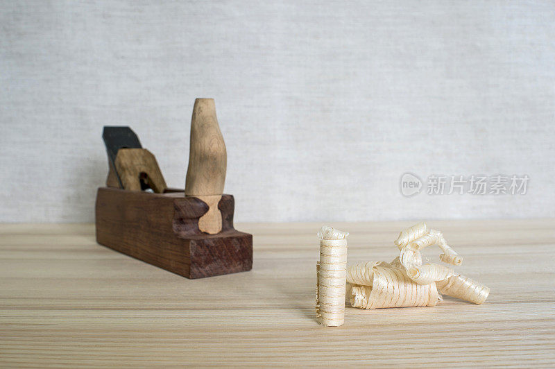 手工制作的木刨子和木屑放在桌子上特写。DIY的概念。木工和工艺品的工具。