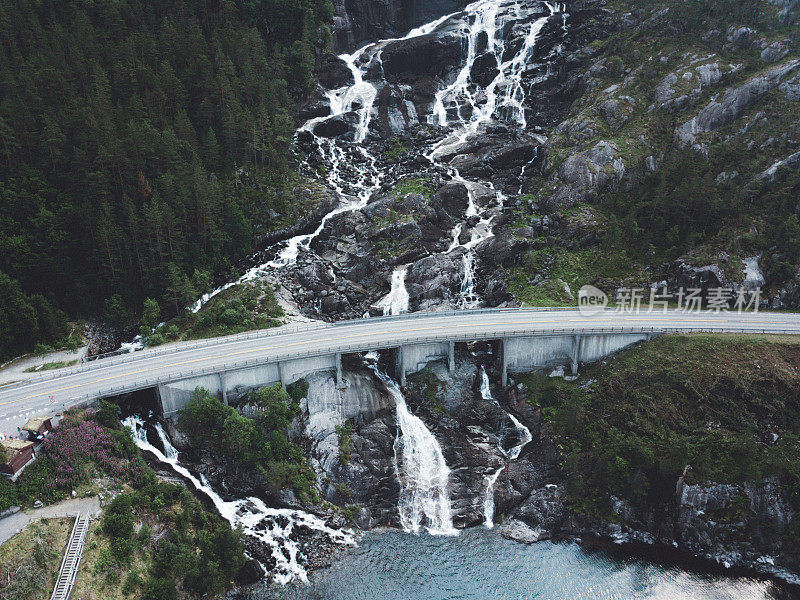 鸟瞰图，巨大的瀑布落入挪威的绿松石湖和道路