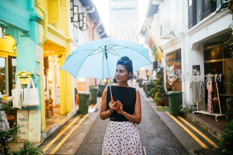 旅女在雨中探索新加坡的小巷子