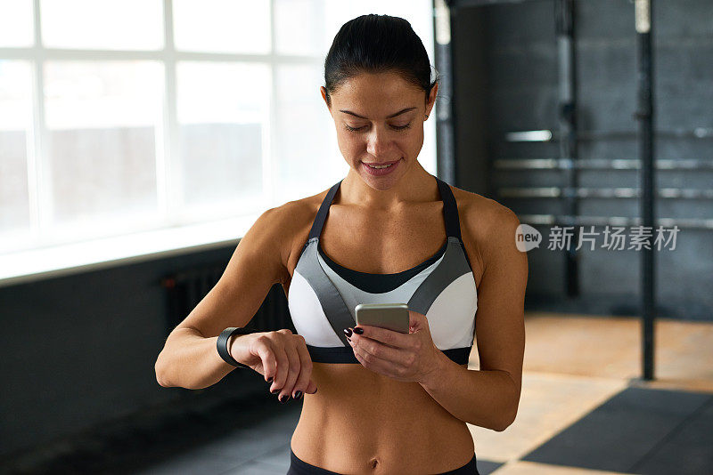 健身女性使用智能手机和手表