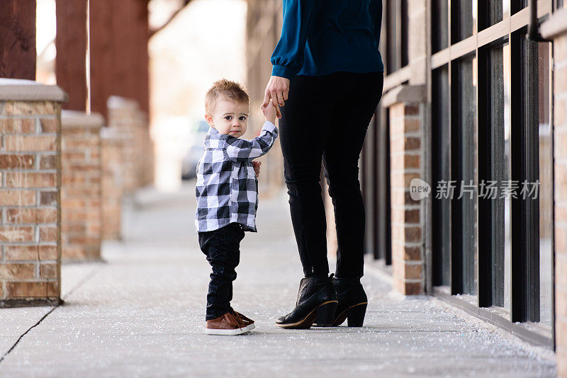 悲伤的孩子握着妈妈的手