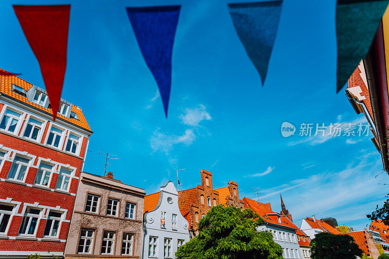 德国北部石勒苏益格-荷尔斯泰因的吕贝克老城，中世纪街道，被多色的三角形旗帜围成一圈。
