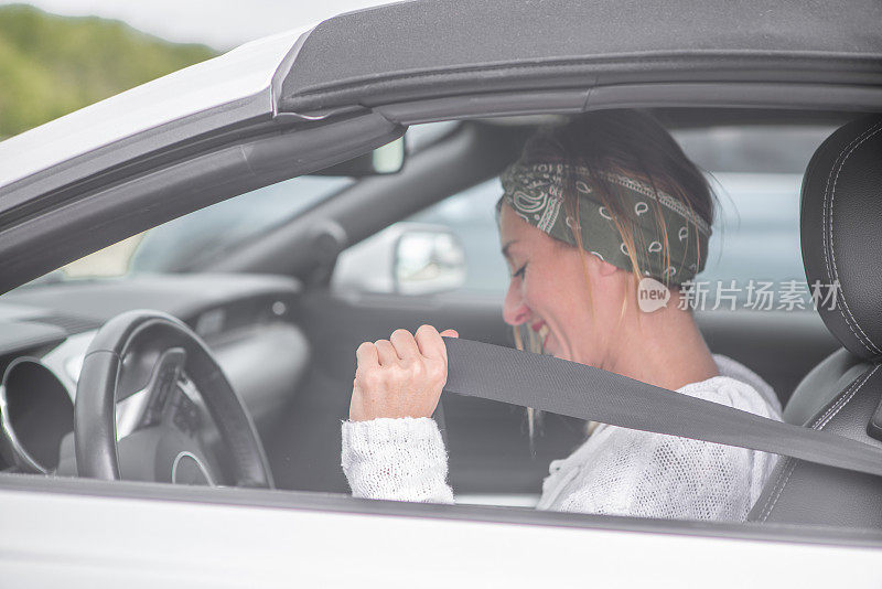 年轻女子在车上系好安全带准备开车-安全理念