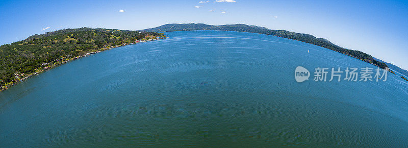 从空中俯瞰加州克利尔湖上白金汉公园的低空风景，停泊着游艇。阳光明媚的春日。高分辨率超宽拼接全景图。