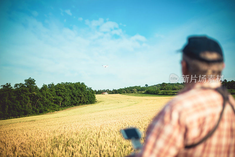 一名男子驾驶无人机飞过谷物田