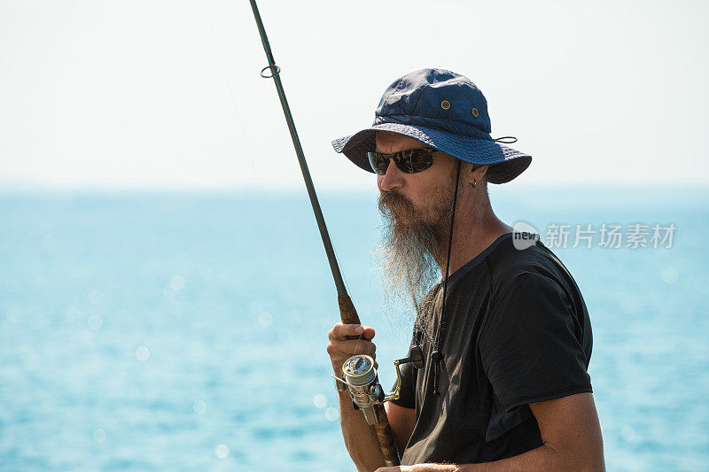 出海垂钓，人在阳光明媚的夏日垂钓