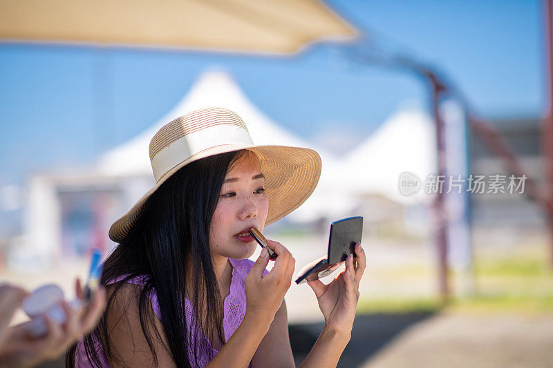 夏天在海滩上化妆的年轻女子