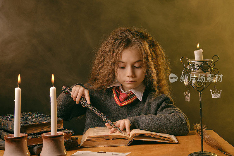 穿着黑衣服的小女巫坐在桌子旁，背靠黑烟的背景在读一本书。特写肖像