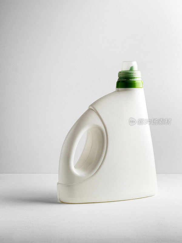 塑料容器，白色背景上的洗衣粉瓶，白色塑料瓶绿色盖子隔离在白色上。