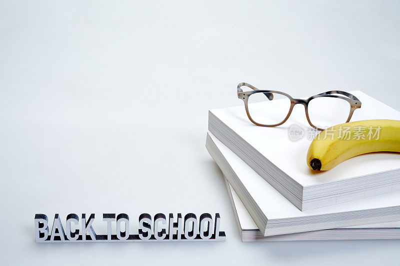 回到学校课本旁边的书页和香蕉加眼镜躺在上面