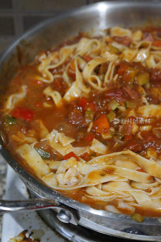用平底锅煎制的意大利面带，配上红绿青椒，涂上香草番茄肉酱和磨碎的帕玛森奶酪