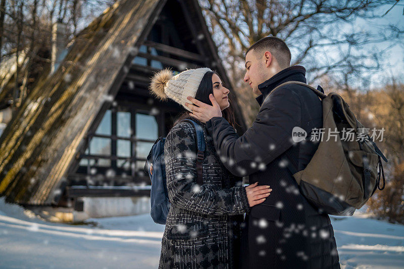 这对快乐的情侣在雪山徒步旅行时微笑着用手机自拍