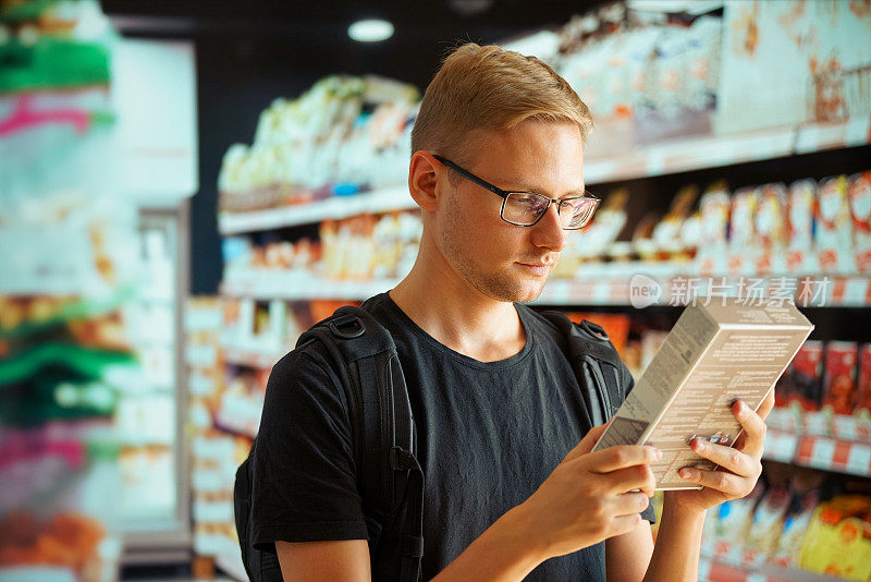 一个男人在商店里比较不同包装的产品