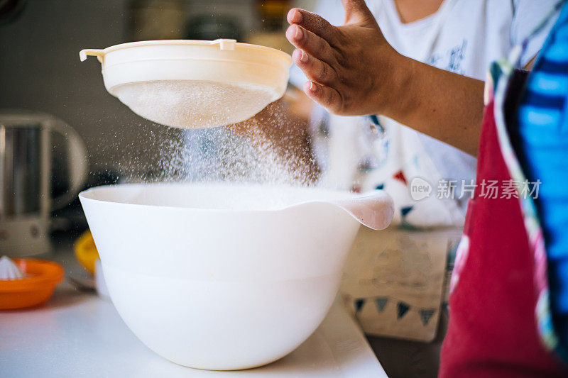 幸福家庭在厨房。母亲和孩子准备面团