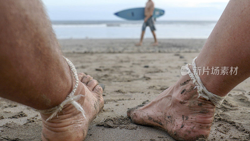 在太平洋海岸线的早晨，可以看到过去的成熟夫妇的脚