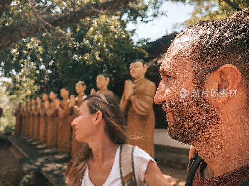 一对夫妇在古庙里瞻仰佛像