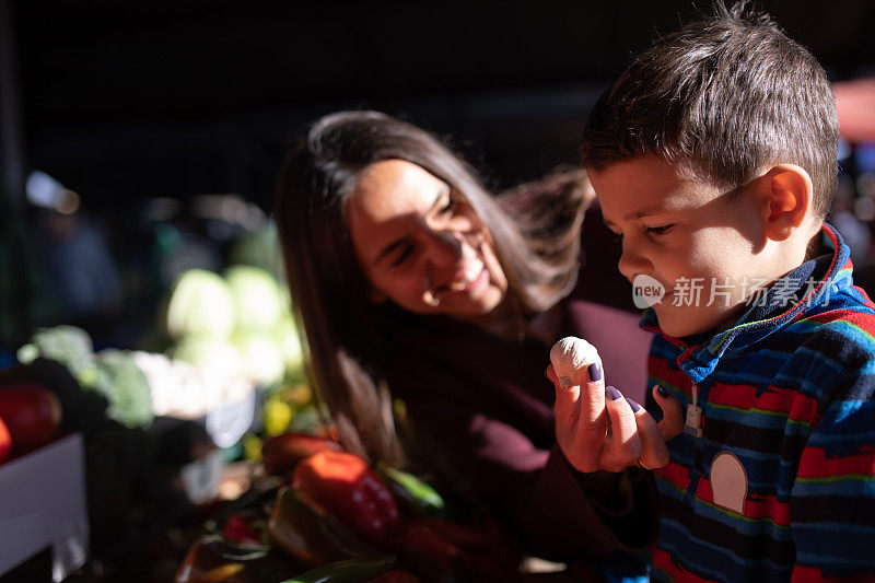 一个可爱的男孩在农贸市场闻到了大蒜味