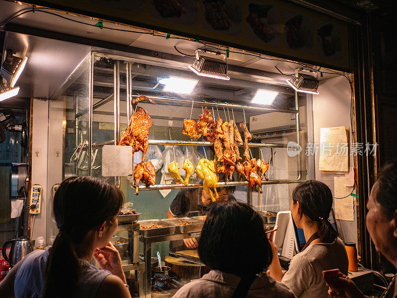 广州闹市区巷子里，一群素不相识的人在买烧鸡。广州是广东省的省会，是中国第三大城市