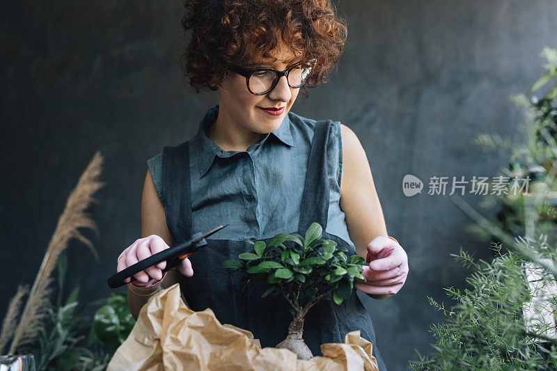 微笑的女人园丁照顾盆景树