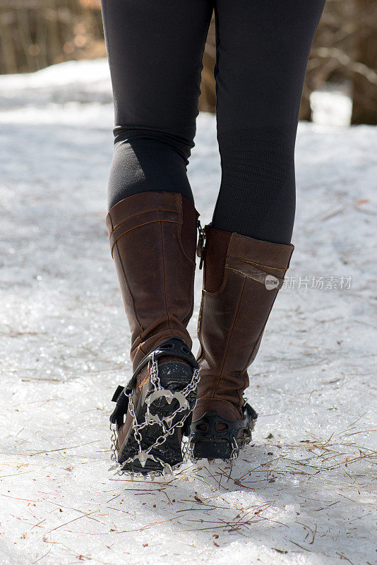 在加拿大冰天雪地的徒步旅行路线上，用于冰上的女性皮革亭子上的钢制牵引钉鞋