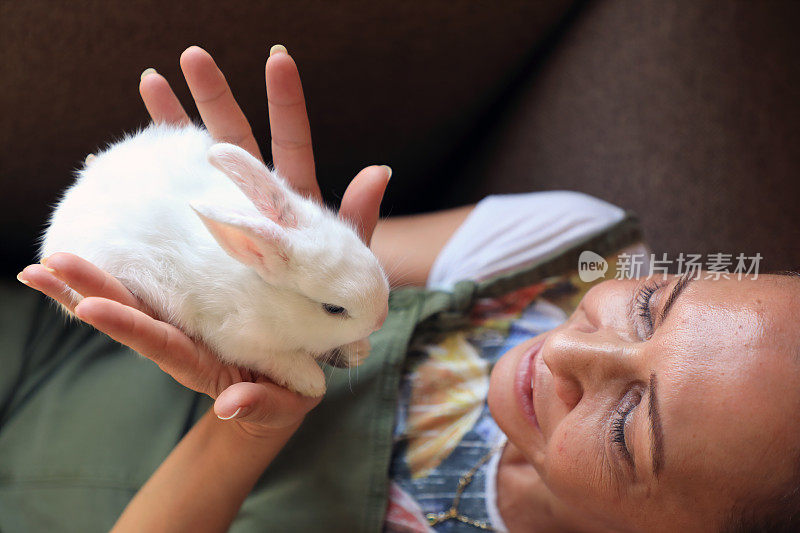 中年妇女手中抱着小兔子的肖像