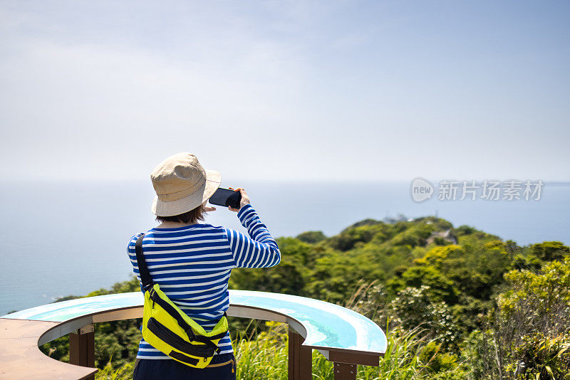 年轻女子在山上的观察点拍照