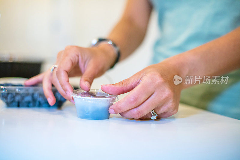 千禧女性在厨房用塑料容器做饭照片系列