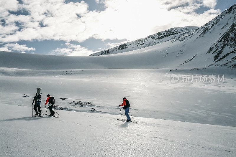 三个偏远地区的滑雪者正在攀登一座雪山