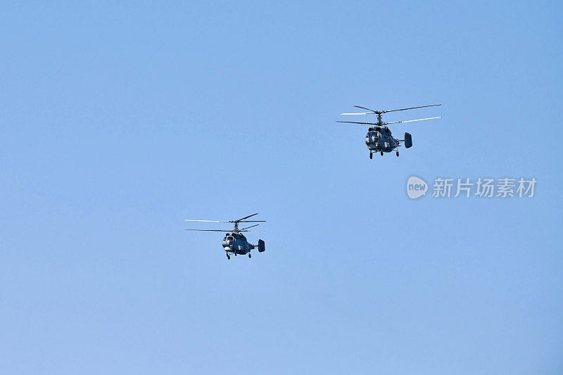 两架军用直升机在湛蓝的天空中表演特技飞行表演队