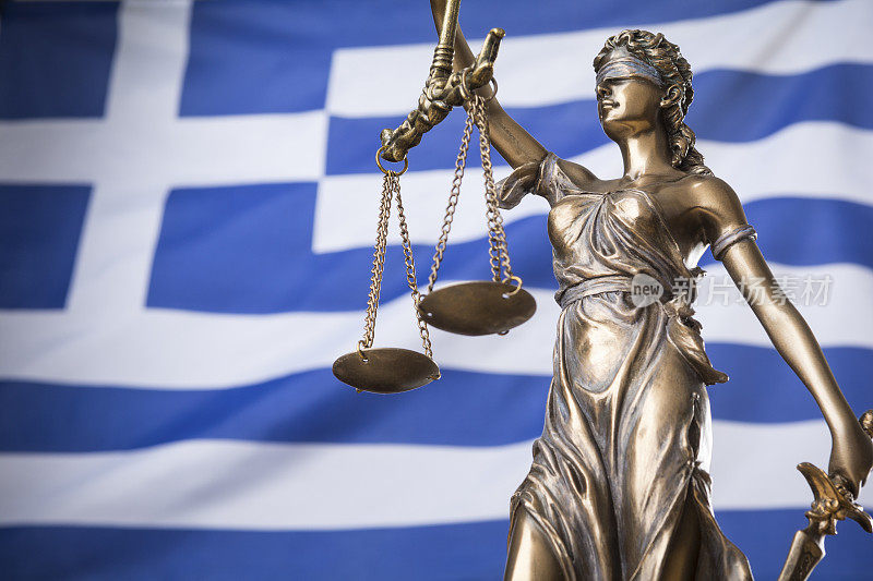 正义的雕像Themis或justtia，被蒙上眼睛的正义女神，面对着希腊国旗，作为一个法律概念