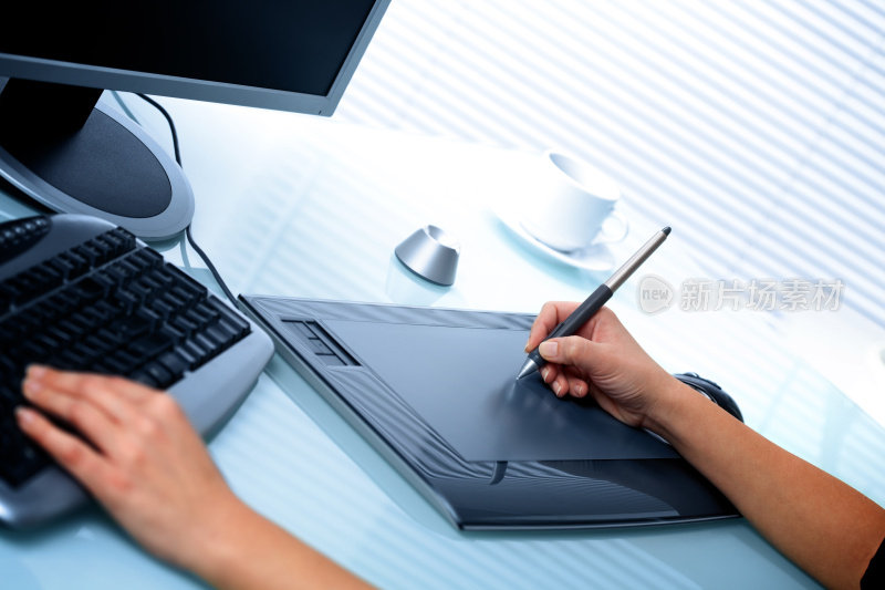 平面设计师在办公室使用数字平板电脑和电脑