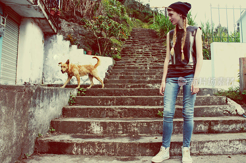 厄瓜多尔，一个女孩带着一只狗爬上了一座山的楼梯
