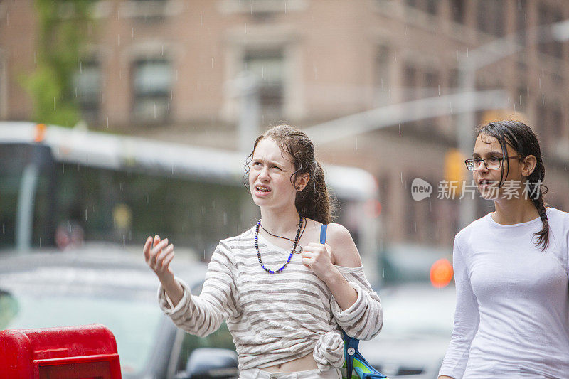 两个十几岁的女孩下雨天在曼哈顿大街上散步