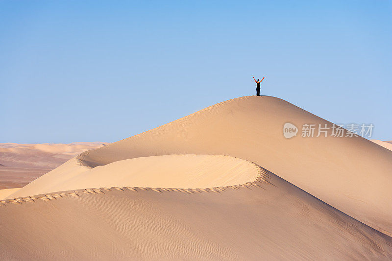 女游客站在撒哈拉沙漠的沙丘顶部